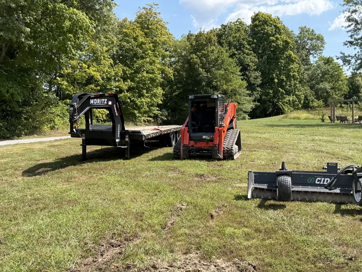 Ground Force Land Solutions compact track loader and equipment trailer staged on a job site